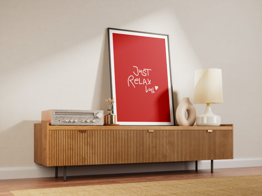 Poster mit der Aufschrift - Just Relax lul - auf einem Sideboard als Holz