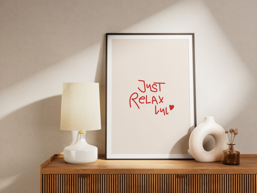 Poster mit der Aufschrift - Just Relax lul - auf einem Sideboard als Holz